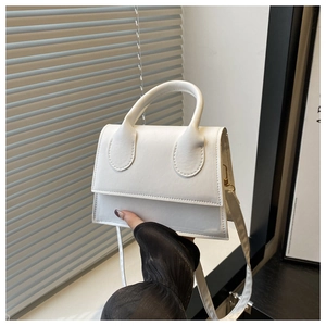 Detail of white PU leather crossbody bag with top handle and golden hardware finish