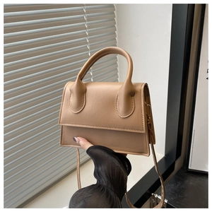 Detailed macro view of camel PU leather handbag texture with top handle and strap