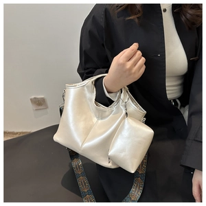 Dettaglio della borsa a secchiello bianco perlato con ampia tracolla a stampa boho