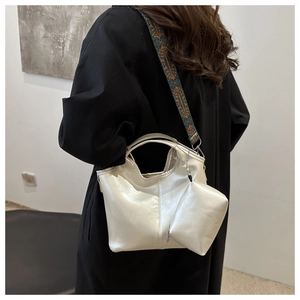 Dettaglio borsa a secchiello argento con tracolla ricamata boho e pochette