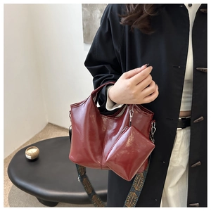 Dettaglio della borsa a secchiello in finta pelle bordeaux con tracolla etnica ricamata