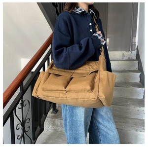 Detail of khaki canvas tote bag with multiple flap pockets in a lifestyle setting