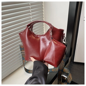 Dettaglio borsa a secchiello bordeaux con tracolla boho larga e pochette coordinata