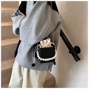 Détail du sac à chaîne cube noir avec poignée en perles et pochette intérieure
