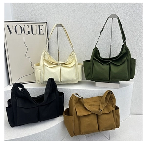 Group shot of large canvas tote bags in cream, olive, black and khaki on a modern stand