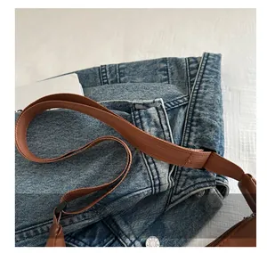 Detail of adjustable brown nylon shoulder strap with leather ends and durable plastic buckle