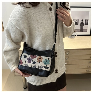 Detail of vintage tote bag featuring floral jacquard panel and black faux leather strap