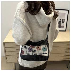 Chic tote bag with floral jacquard panel and sleek shoulder strap in home setting