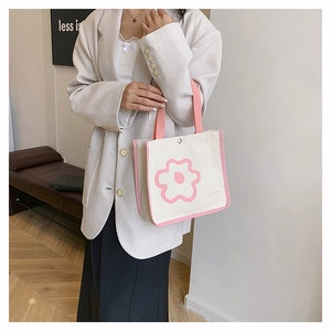 Detailed shot of canvas tote bag with pink floral print and magnetic closure