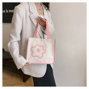 Close-up of small canvas tote bag with pink flower print and snap button detail
