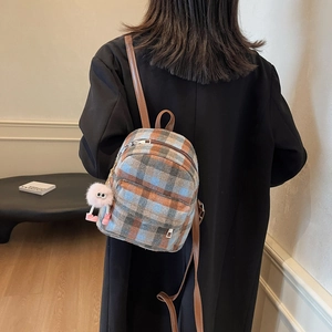Schicker Tweed-Karo-Minirucksack in Blau und Braun mit Plüschanhänger am Modell
