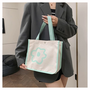 Detail of canvas tote bag showing mint green flower print and snap button closure