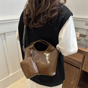 Borsa a secchiello marrone scuro lucida con tracolla larga in stile jacquard vintage
