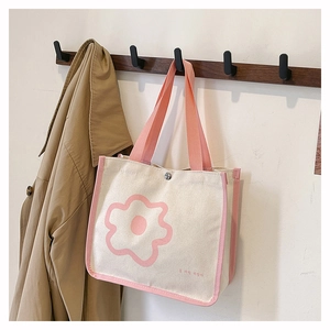 Detail of canvas tote bag with pink flower print and silver metal snap button closure