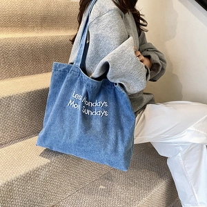 Borsa tote in denim blu con ricamo Les Mondays Mon Sundays mostrata su modella