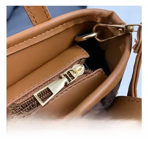 Close-up of premium gold-toned metal zipper and leopard print fabric on a brown bucket bag