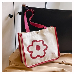Detail of minimalist canvas tote bag featuring red floral print and magnetic metal clasp