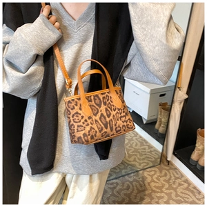 Detailed view of leopard print bucket bag with dual handles and adjustable strap