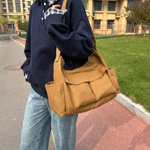 Large khaki vintage canvas messenger bag for travel and daily commute in outdoor setting