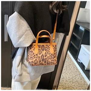 Close-up of leopard print bucket bag featuring brown PU leather handles and slim strap