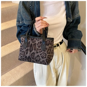 Detailed side view of leopard print bucket tote bag with black leather handles for women