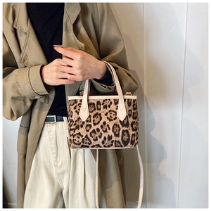 Detail view of stylish leopard print bucket bag paired with a classic khaki trench coat