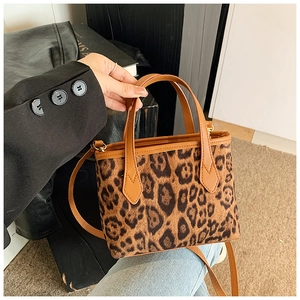 Detail of leopard print suede bucket bag showing texture, leather handle and strap