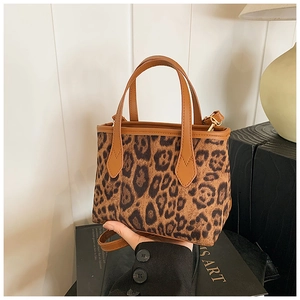 Close-up of leopard print mini tote bag with premium brown leather straps and gold hardware