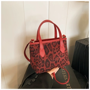 Detail of red leopard print bucket bag with dual handles and detachable shoulder strap