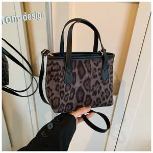 Detail of leopard print bucket bag with faux fur texture and black leather handles