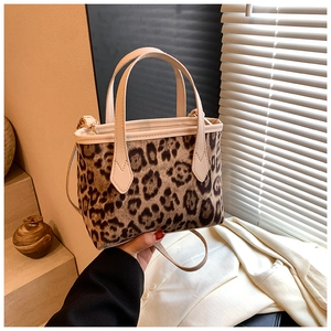 Detail of leopard print tote bag with cream leather straps and crossbody strap