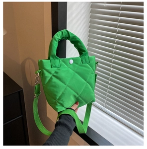 Close-up of bright green quilted nylon bucket bag with ruffled handle and wide strap