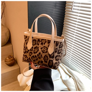 Detail showing leopard print bucket bag with beige leather trim and crossbody strap