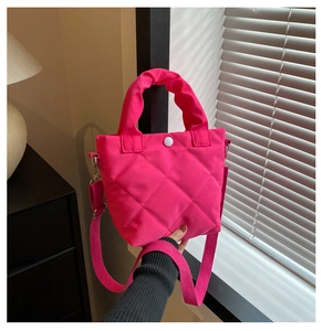 Close-up of fuchsia quilted bucket bag showing diamond stitching and white snap button