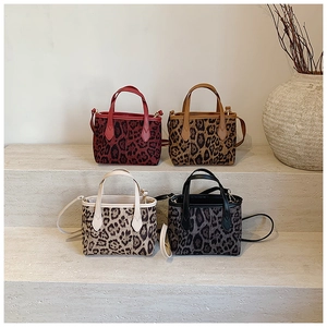 Group display of chic leopard print tote bags in four colors on minimalist steps