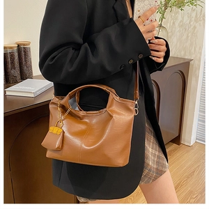 Retro brown PU tote bag with shoulder strap and mini pouch shown in lifestyle setting
