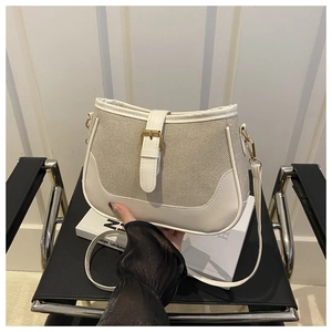 Detail of stylish color-block handbag showing woven fabric texture and white leather buckle