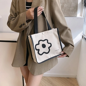 Minimalist canvas tote bag with black flower print and stylish shoulder strap