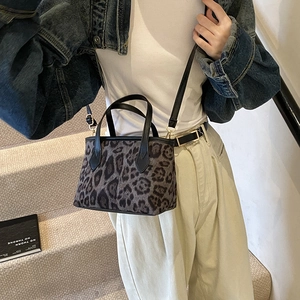 Chic leopard print bucket bag with black leather handles and gold-tone hardware detail
