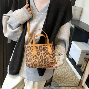 Stylish leopard print bucket bag with brown leather handles and adjustable shoulder strap