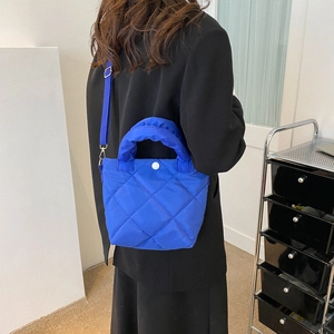 Blue quilted puffer bucket bag for women with padded top handle and crossbody strap