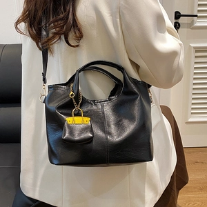 Minimalist black lychee texture bucket bag with mini charm for office women