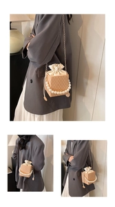 Detail of woven straw box bag with pearl handle and silk drawstring lining