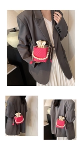 Detail of rose pink textured box bag with pearl handle and golden chain crossbody strap