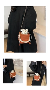 Detail view of orange square bag featuring a pearl handle and drawstring lining