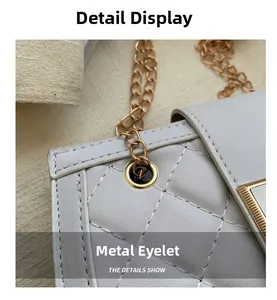 Detailed macro view of gold metal grommets and white quilted leather on crossbody bag