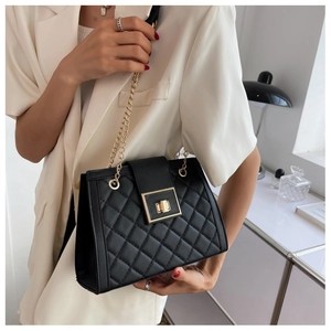 Close-up of elegant black quilted crossbody bag with gold square twist lock and chain strap