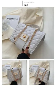 Detail of off-white quilted crossbody bag with gold chain strap and square metal lock