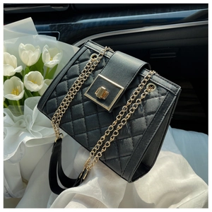 Detail of black quilted leather shoulder bag with gold twist lock and chain strap