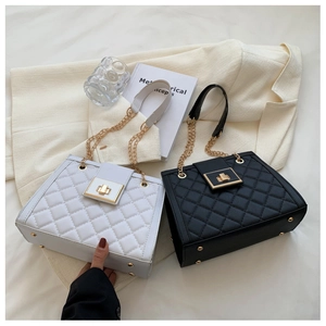 Close-up of quilted pattern and gold metal lock on black and white shoulder bags